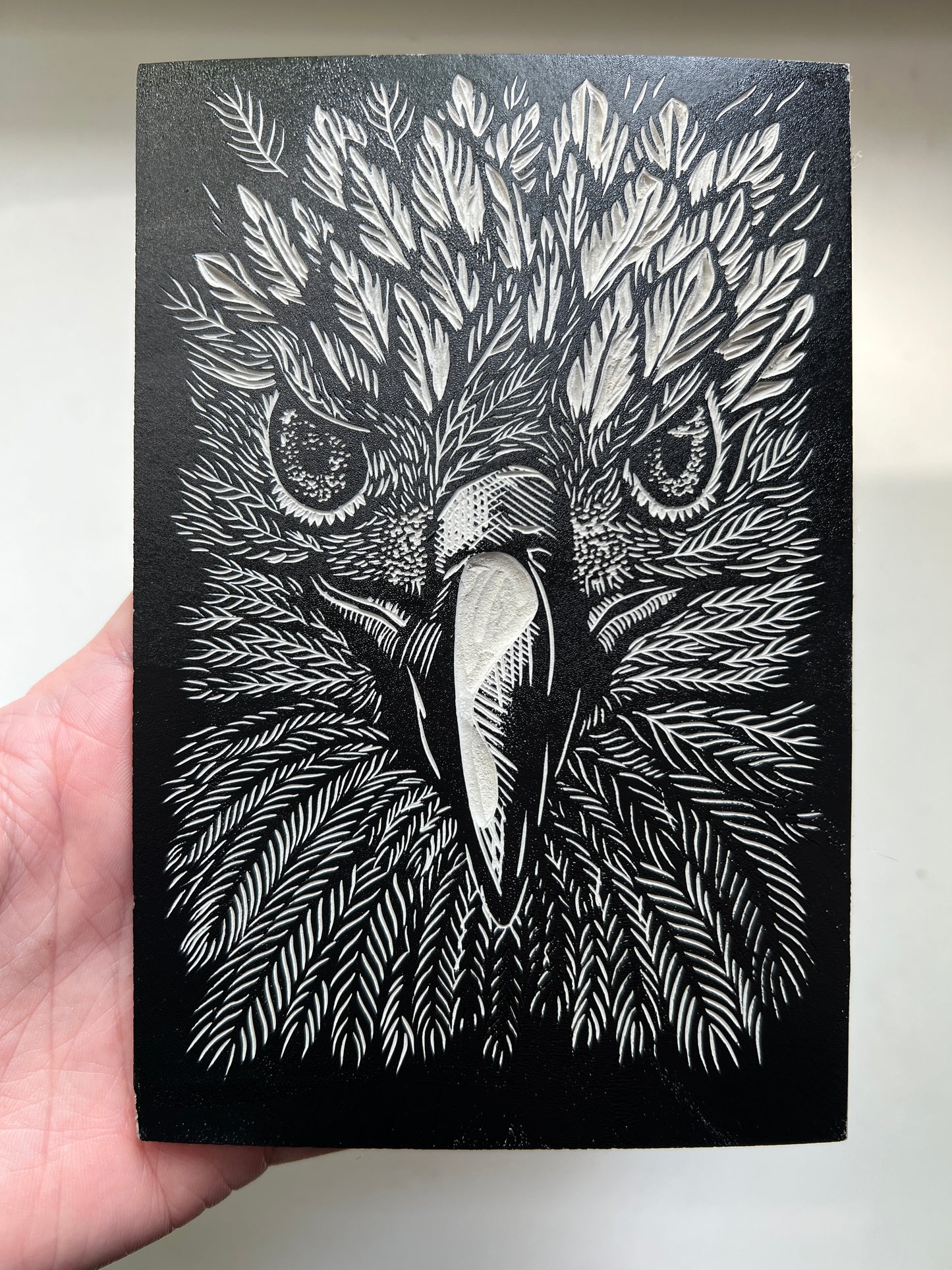 This is a photo of the inked up (black ink) lino block of a golden eagle portrait, before being printed.