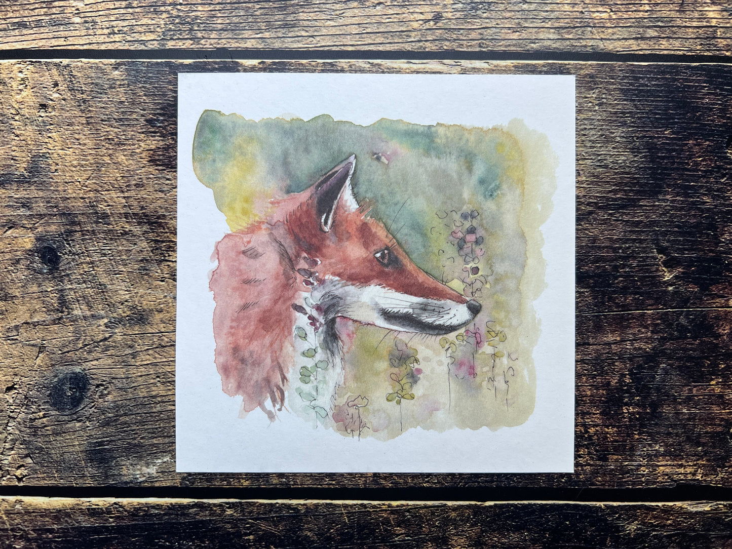 Watercolor painting of a fox on a wooden surface
