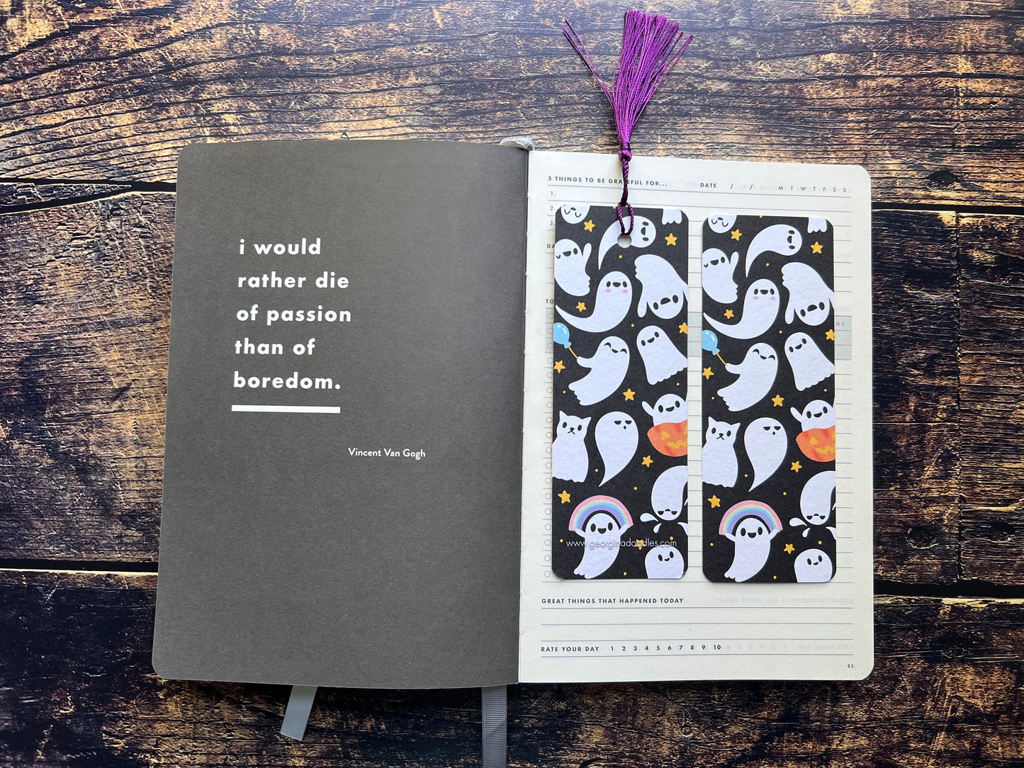 Open notebook with a bookmark featuring ghost patterns on a wooden surface