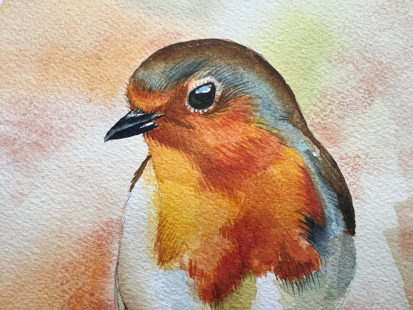 A watercolour painting of a robin, surrounded by blurry autumnal colours.