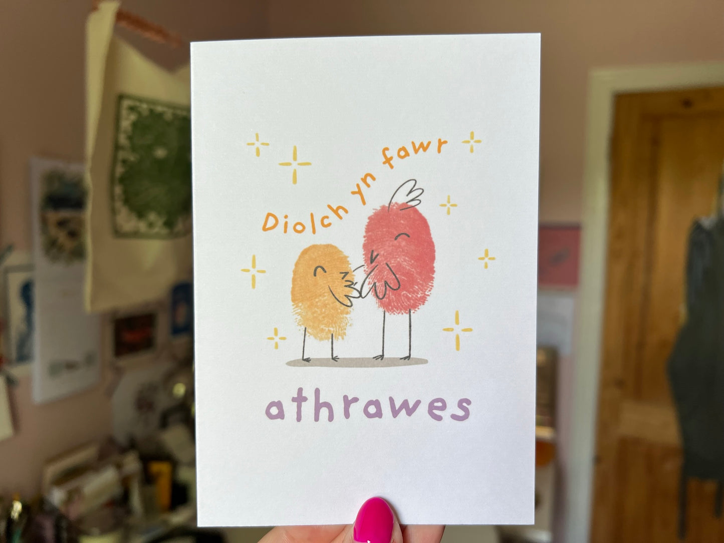 A hand holding a welsh teacher card saying 'Diolch yn fawr athrawes''