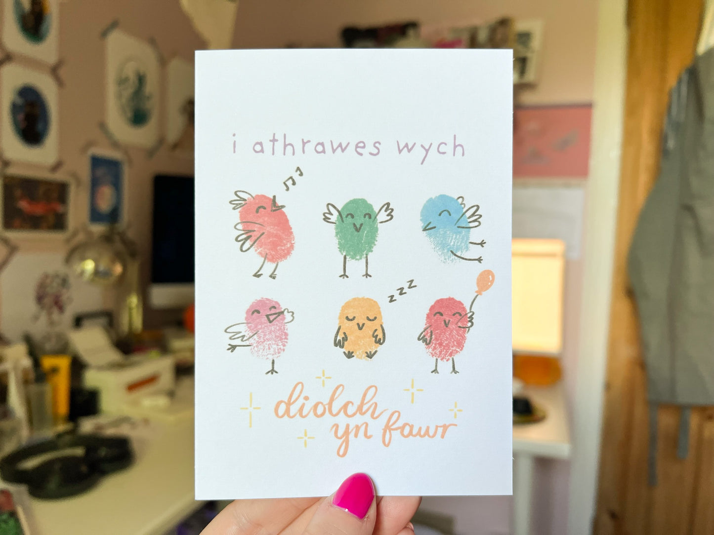 A hand holding a card with six fingerprinted birds on, the card reads 'i athrawes wych, diolch yn fawr'.