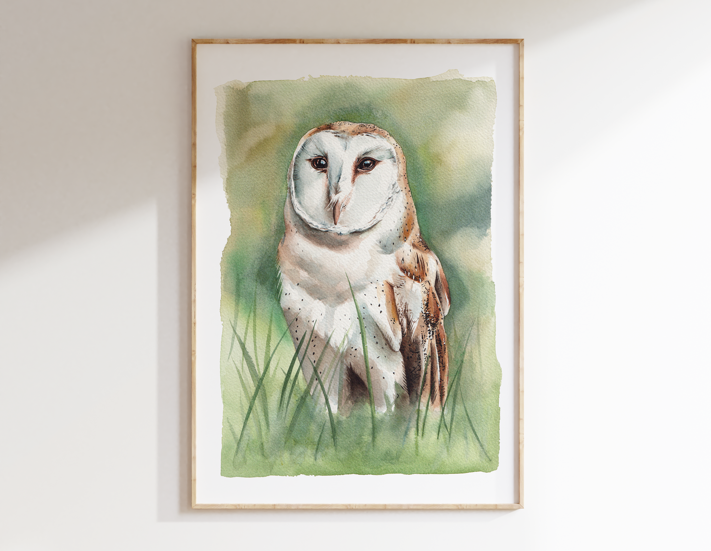 A watercolour print of a barn owl, standing in long grass (so surrounded by green granulated watercolours)
