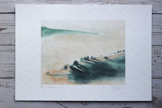 An A4 print of a foggy morning watercolour landscape with dramatic tree shadows