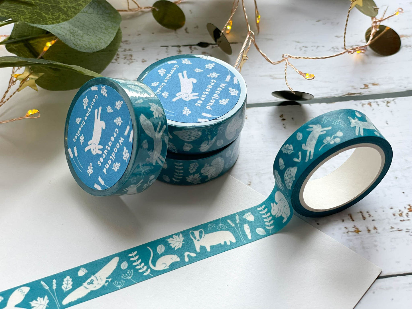 A blue/teal coloured washi tape with white woodland illustrated animals on