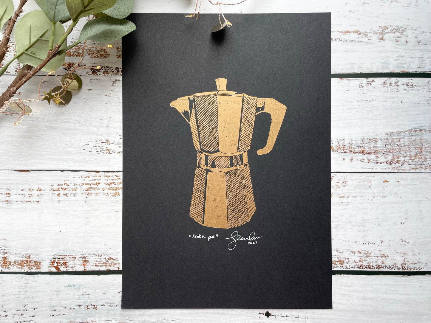 A lino print of a coffee moka pot in copper on black paper