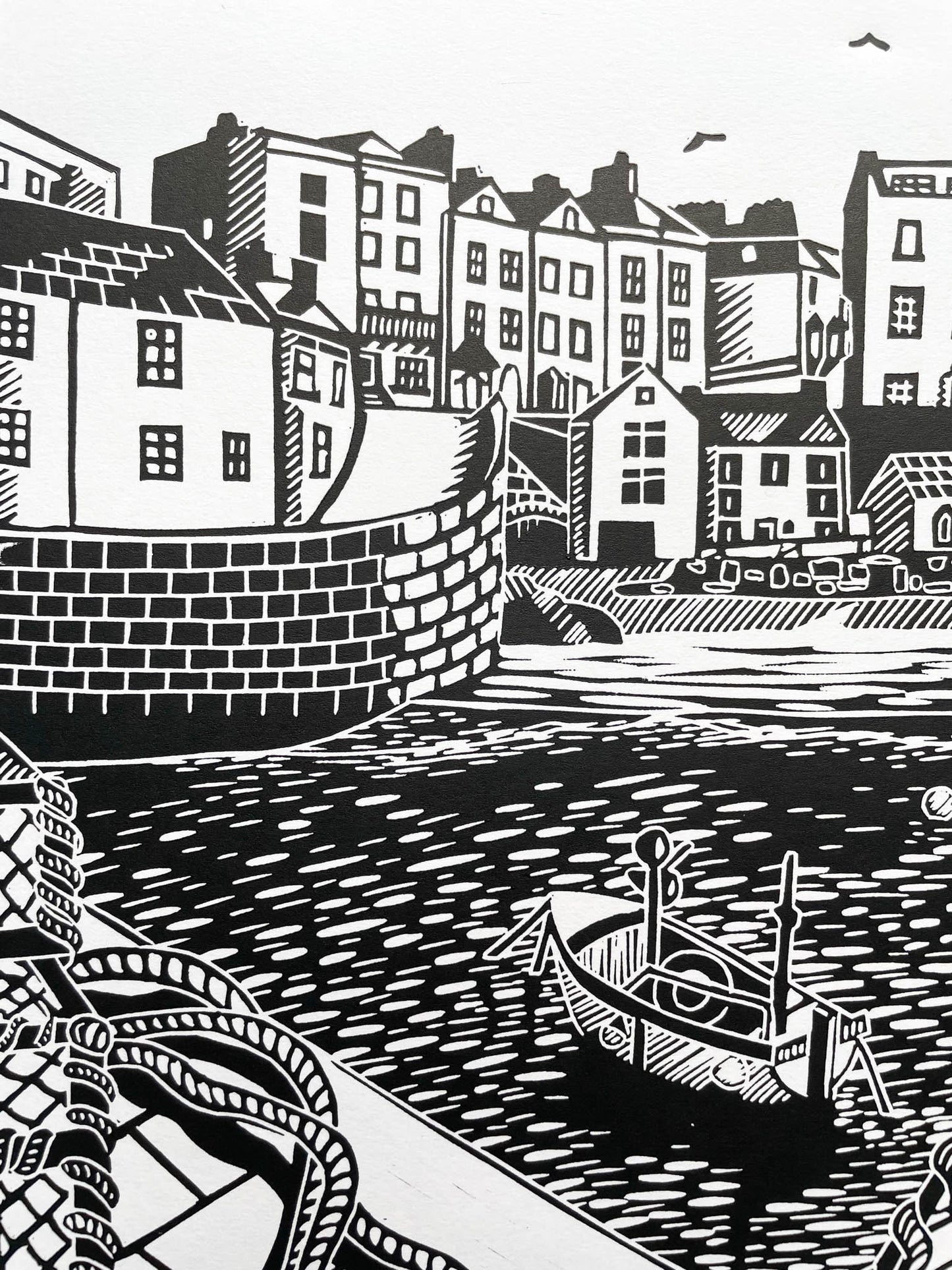 An A4 lino print of the iconic Tenby harbour in black