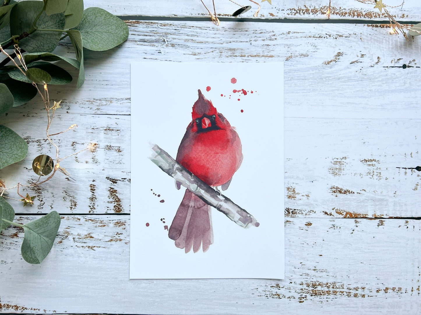 A print of a watercolour painting of a cardinal looking straight at you