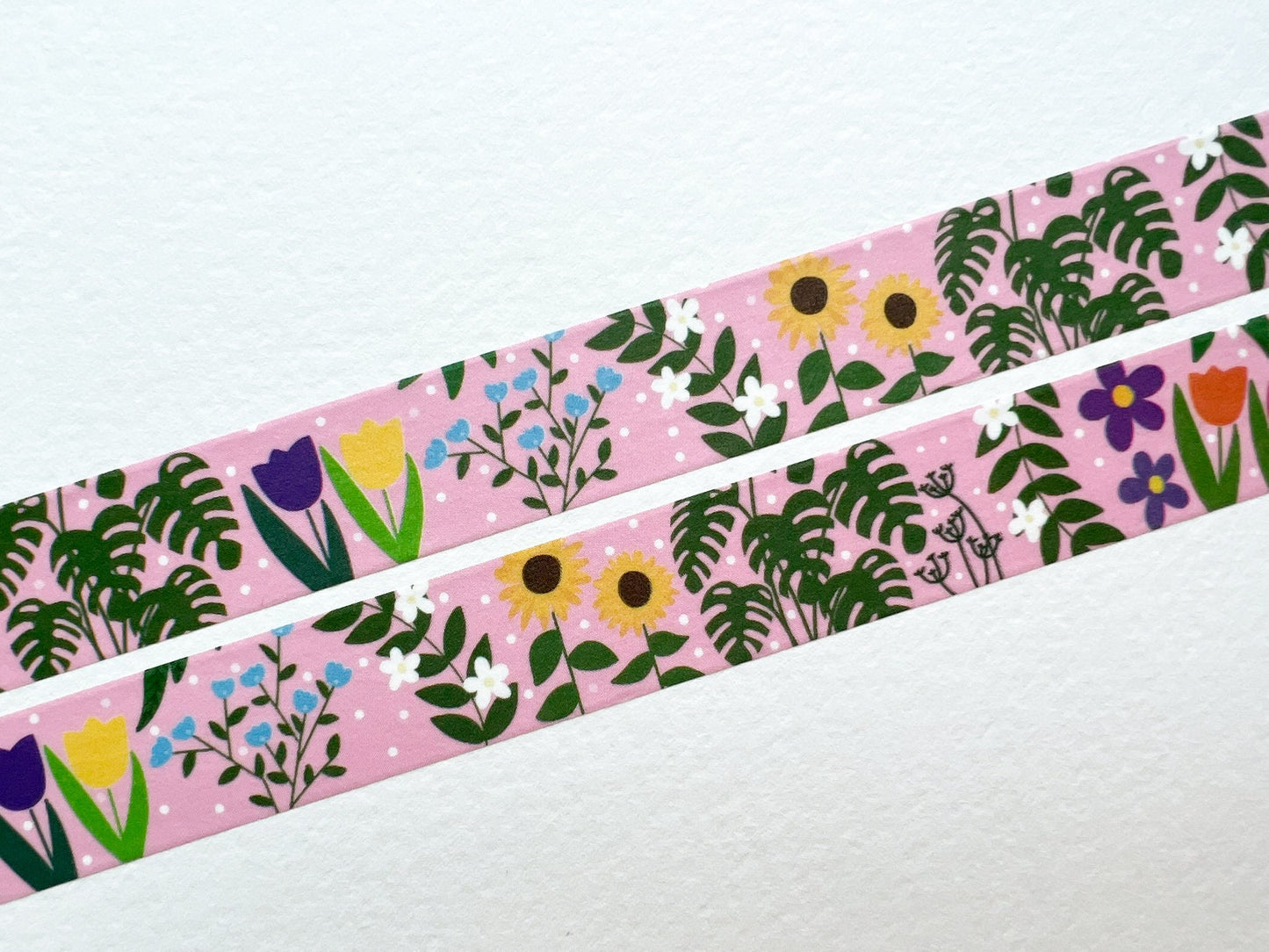 A close up of washi tape with a pink background and covered in flowers