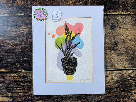 A lino print of an aloe plant on a watercolour background