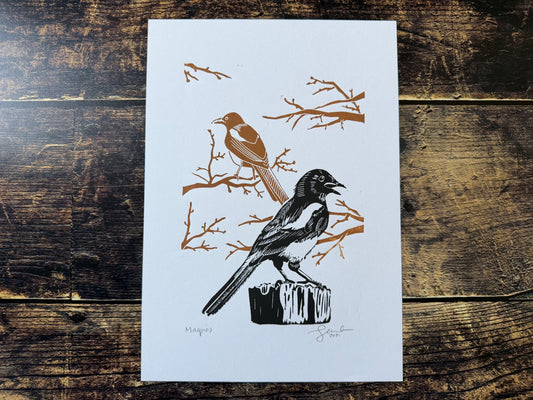 An A4 lino print featuring two magpies