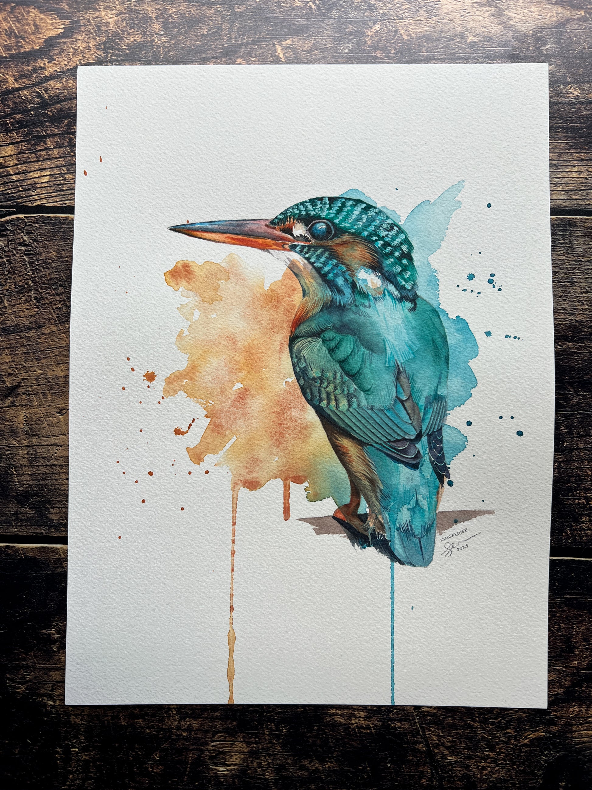 Watercolor painting of a kingfisher on a wooden surface