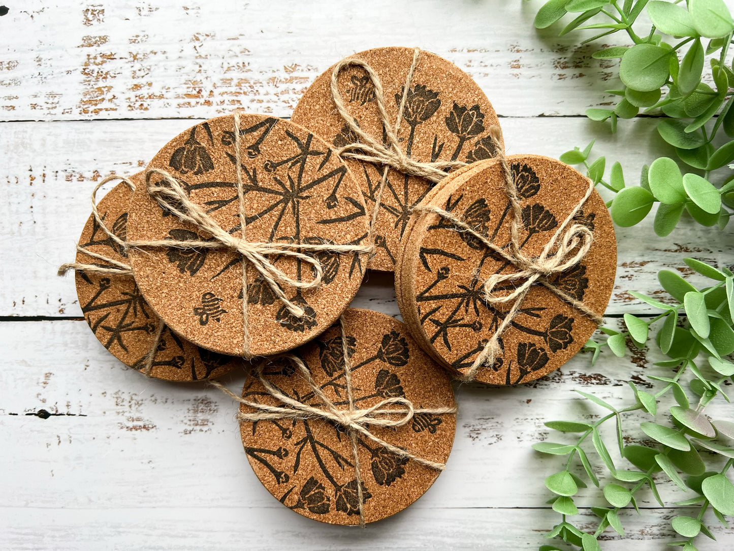 Five sets of 4 cork coasters with a black printed floral motif including a bee