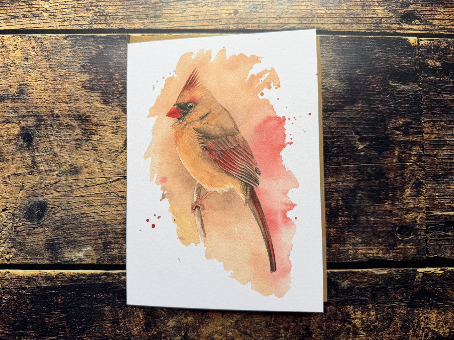 A greetings card with a watercolour print of a female cardinal on the front
