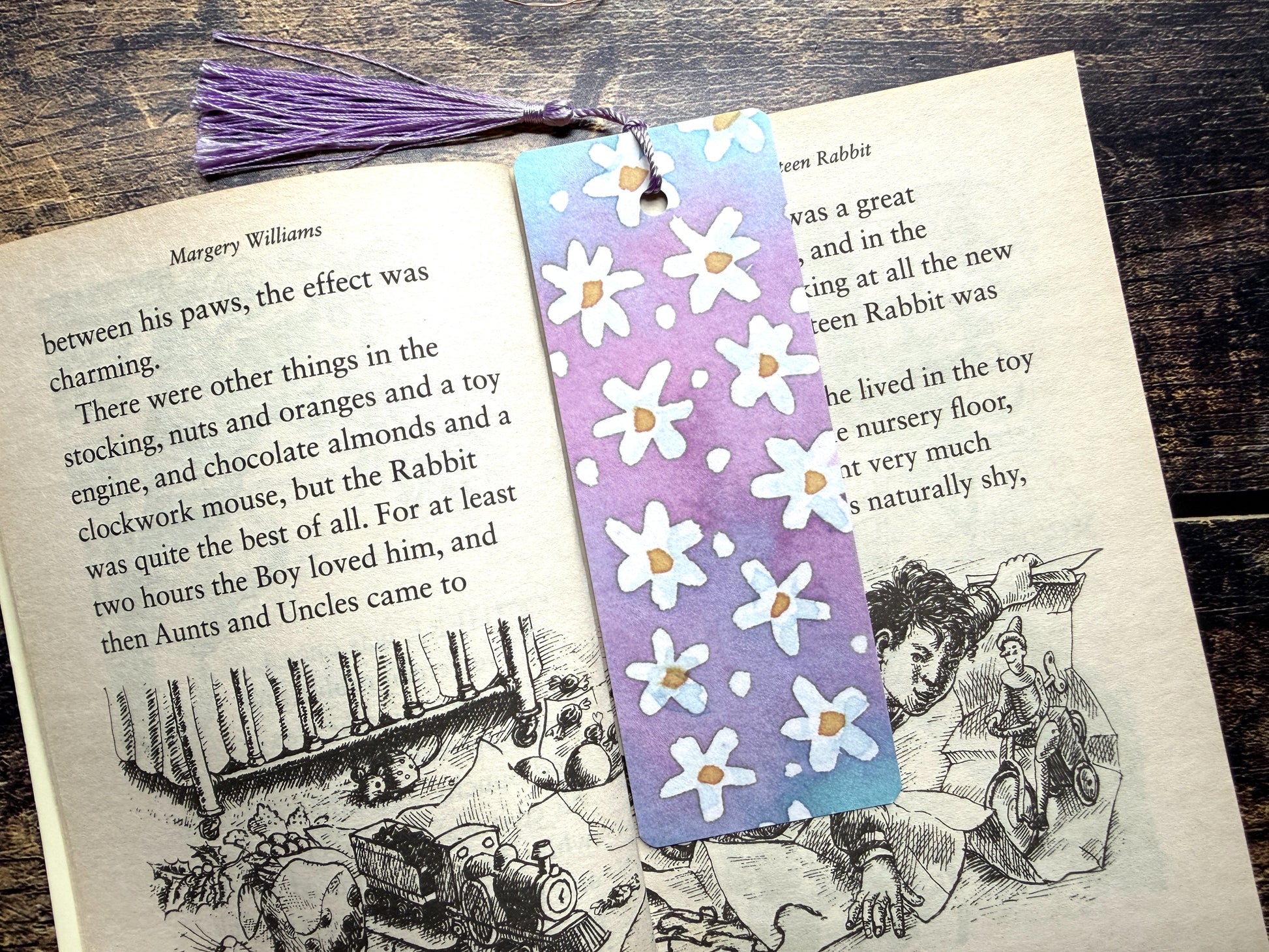 A photo of a watercolour floral bookmark in an open book