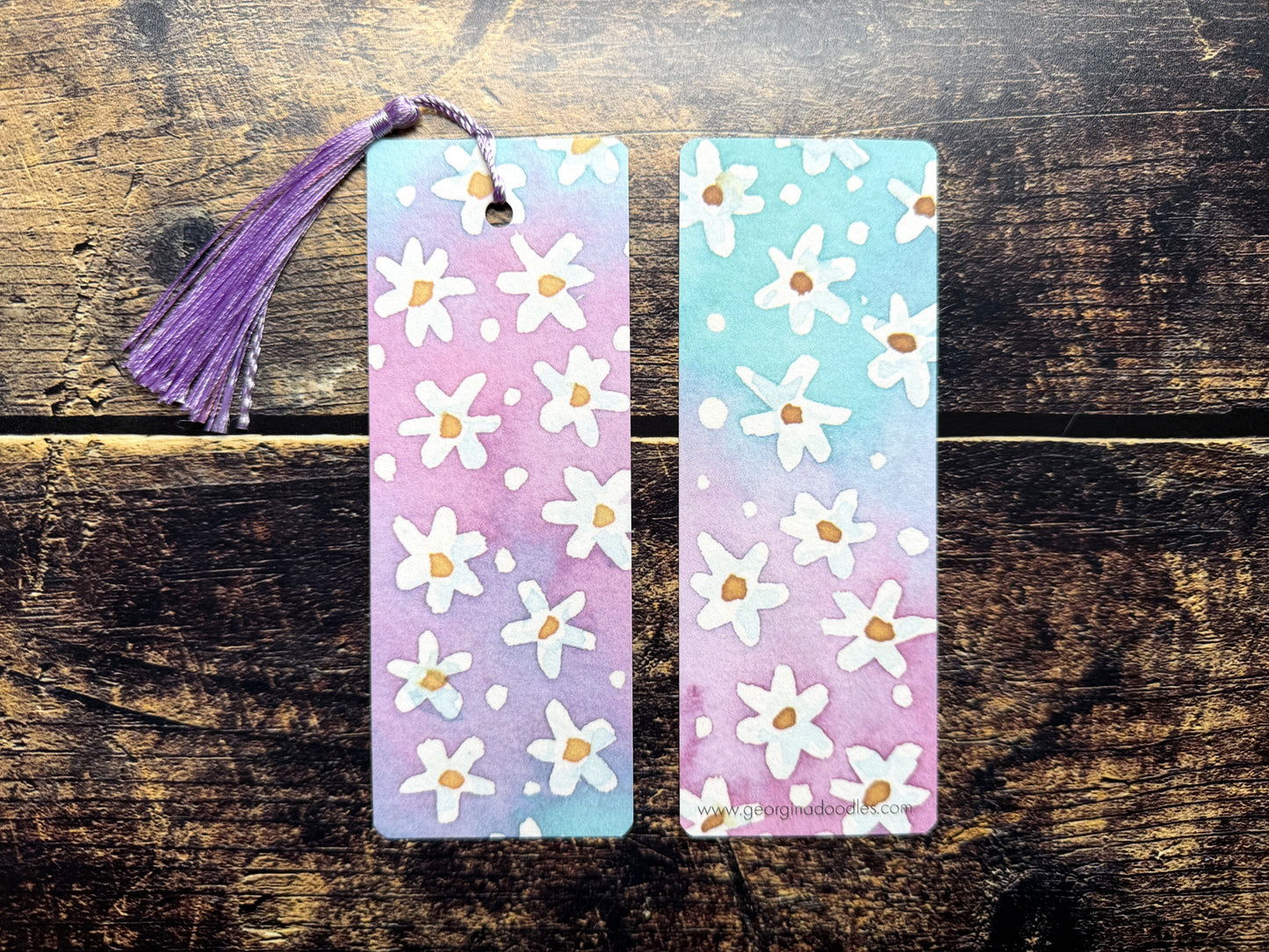 A photo of watercolour floral bookmarks on a wooden background