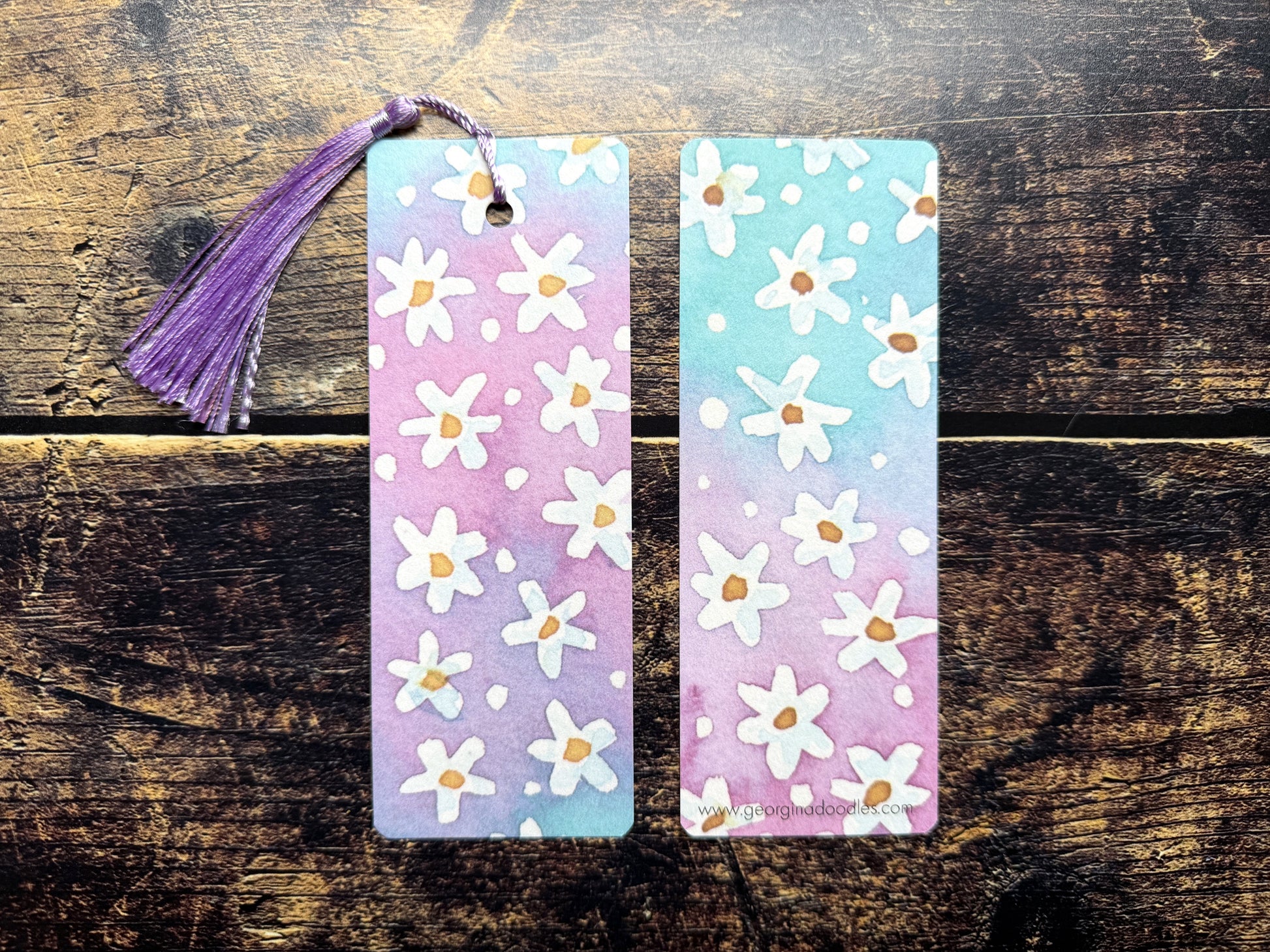 A photo of watercolour floral bookmarks on a wooden background