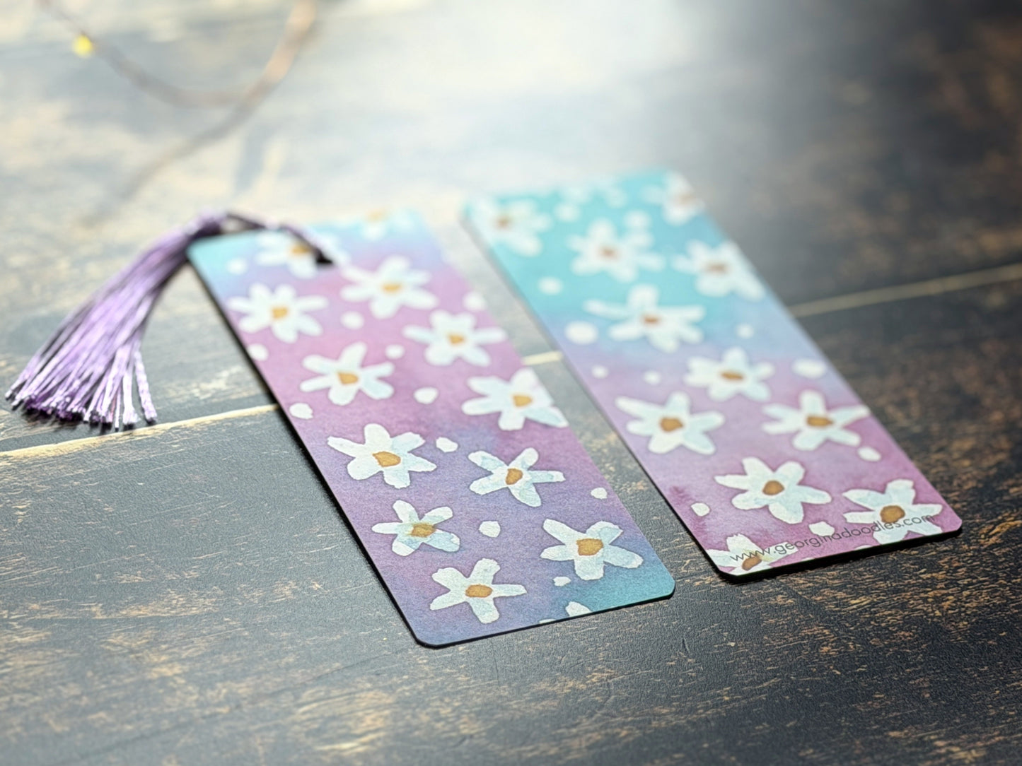 A photo of watercolour floral bookmarks on a wooden background