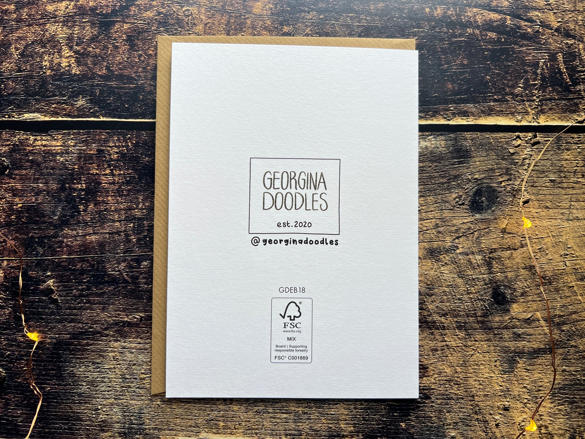 White card with 'Georgina Doodles' branding on a wooden surface