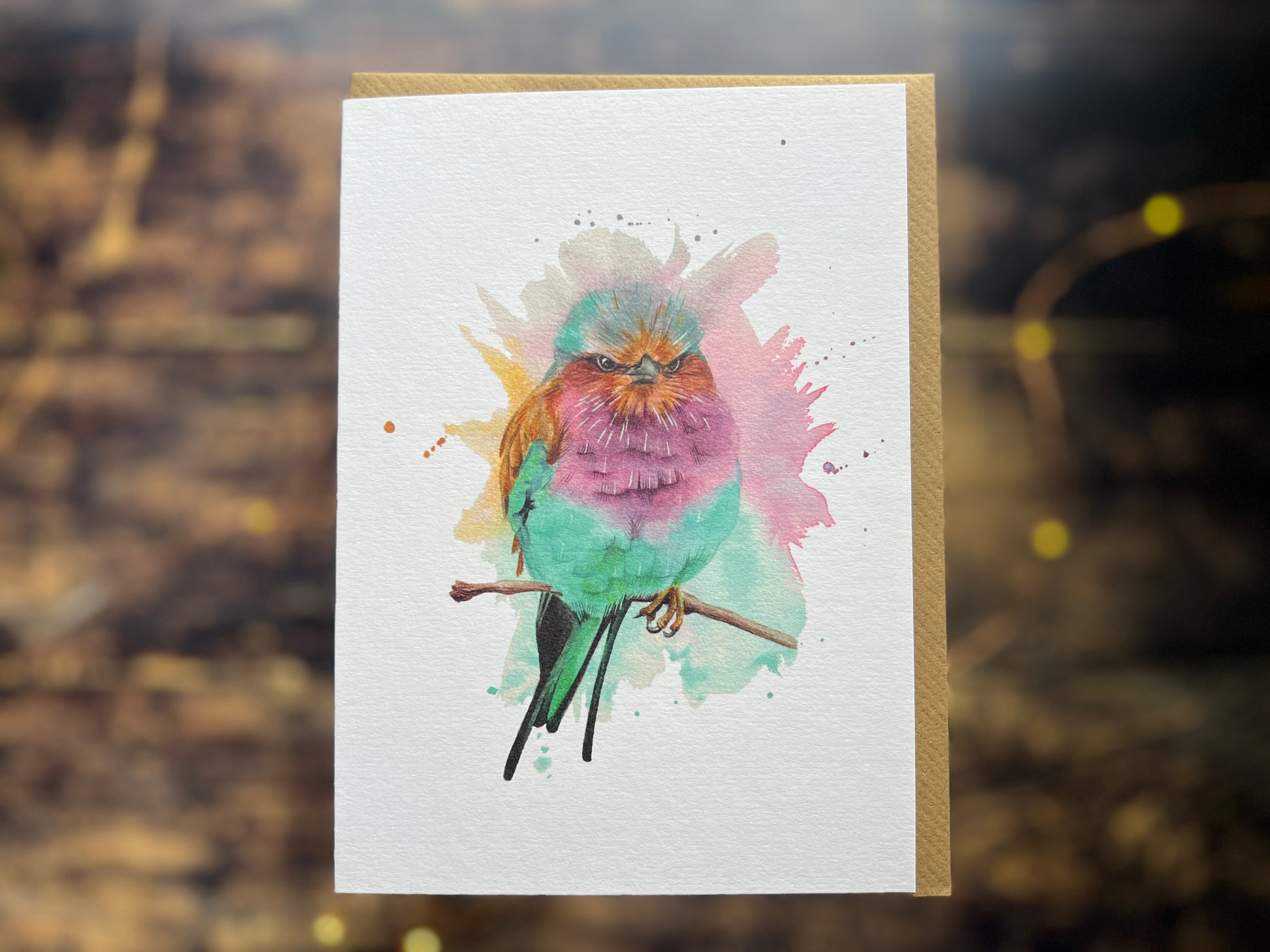 A blank greetings card with a watercolour painting of a lilac-breasted roller on the front.
