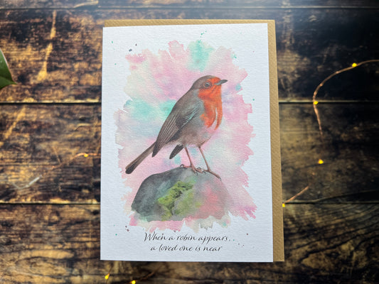 A greetings card featuring a watercolour robin, on the front of the card is says 'When a robin appears, a loved one is near'