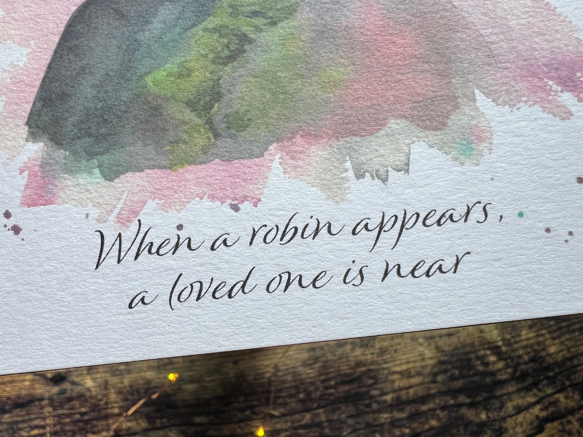 Text 'When a robin appears, a loved one is near' on a watercolor background with a robin illustration.