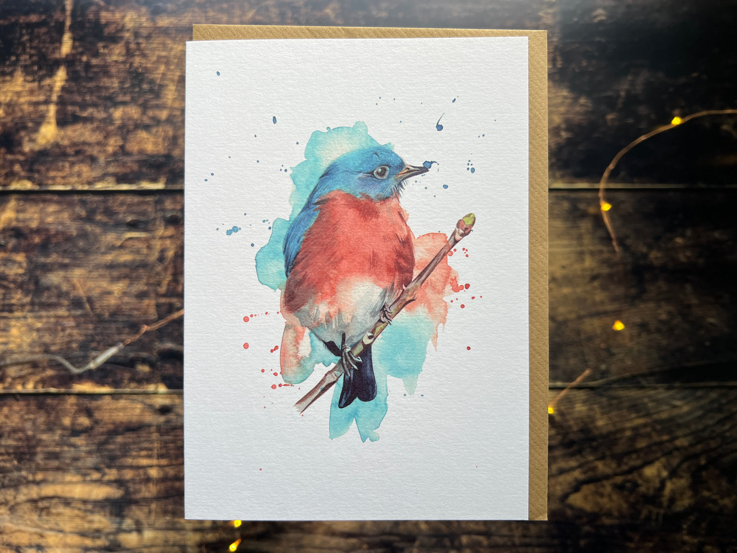A photograph of a greetings card with a watercolour eastern bluebird on the front