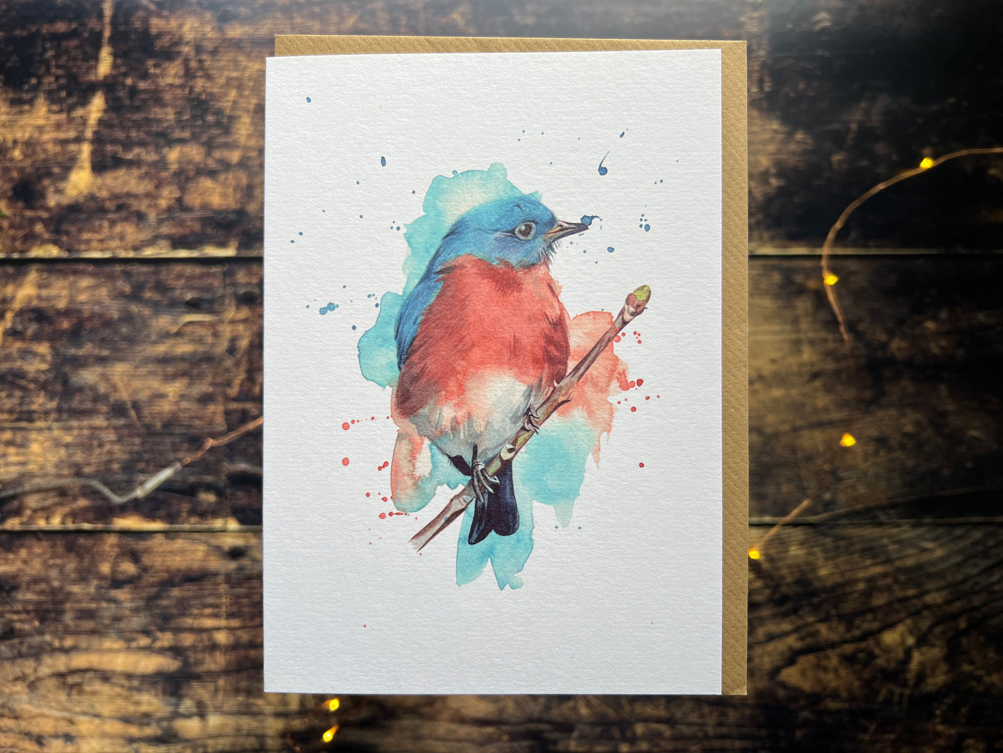A photograph of a greetings card with a watercolour eastern bluebird on the front