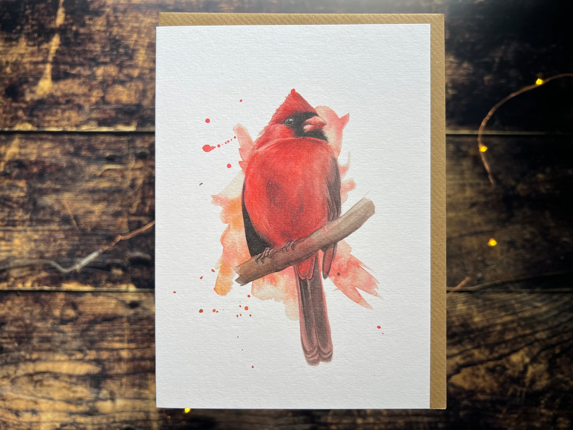 A greetings card featuring a watercolour painting of a male cardinal