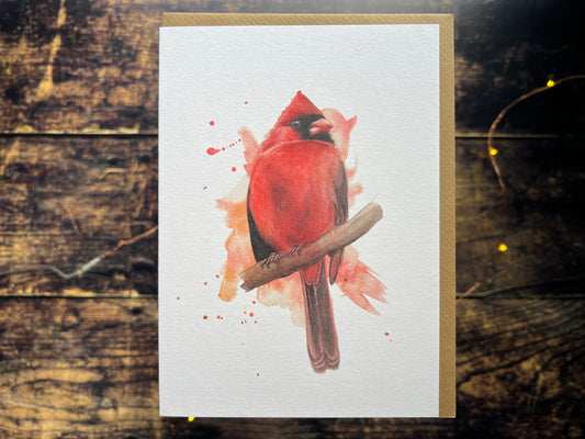 A greetings card featuring a watercolour painting of a male cardinal