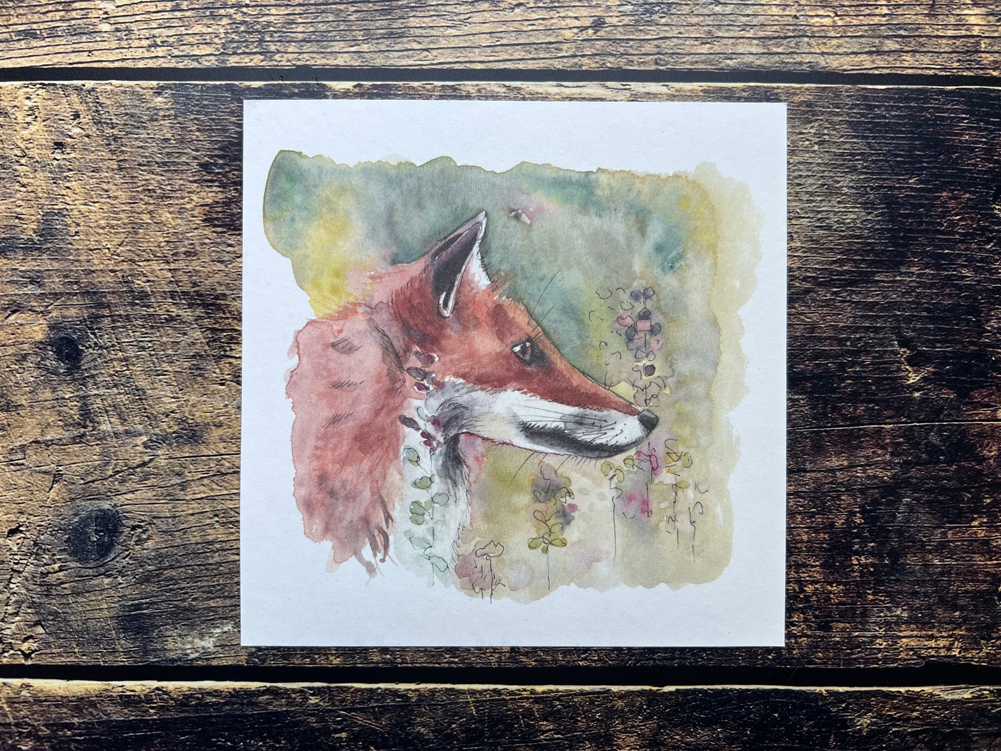 Watercolor painting of a fox on a wooden surface