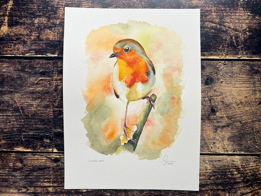 A watercolour painting of a robin, surrounded by blurry autumnal colours.