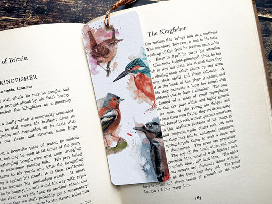 A photo of a bookmark of a collection of expressively painted birds, photographed on an open book