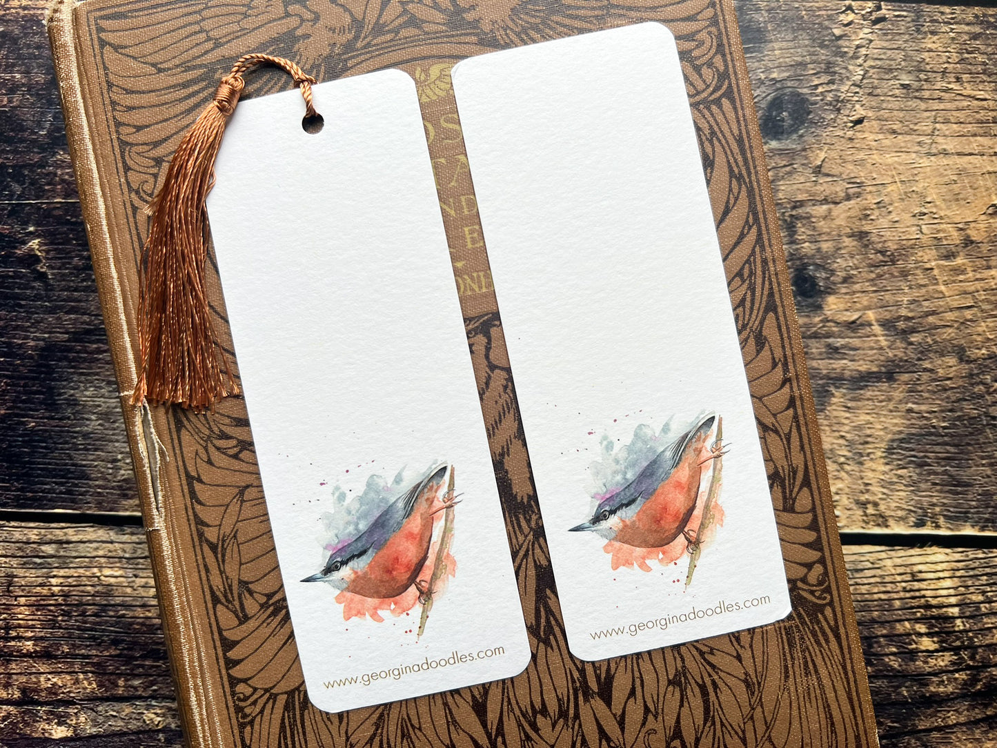 A photo of a bookmark of a collection of expressively painted birds, photographed on a closed book
