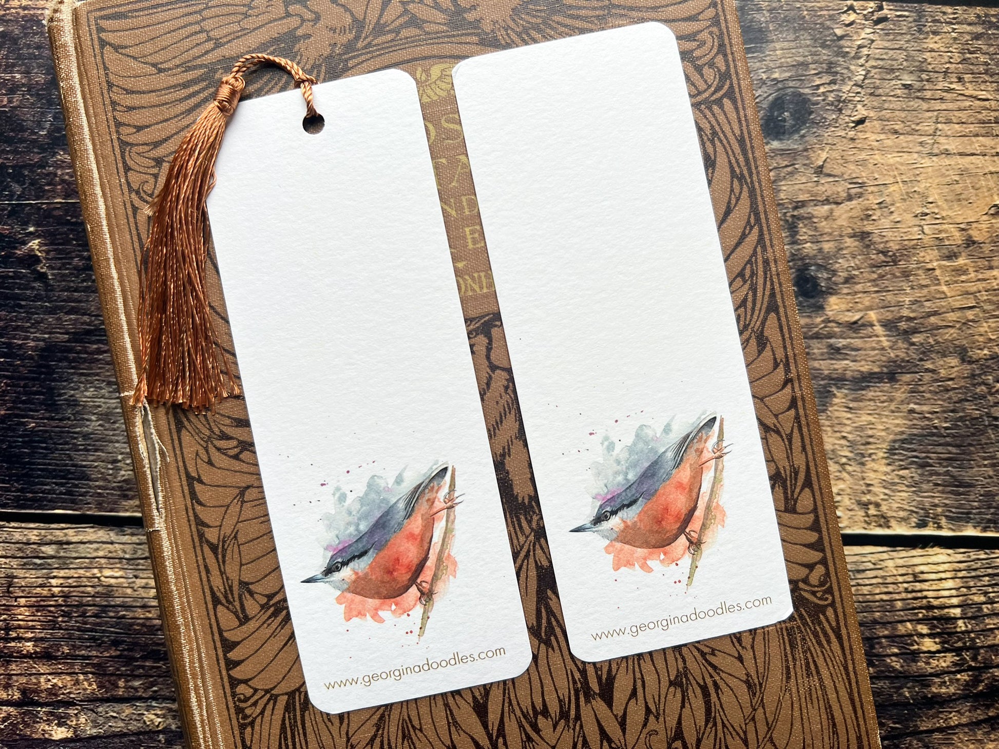 A photo of a bookmark of a collection of expressively painted birds, photographed on a closed book