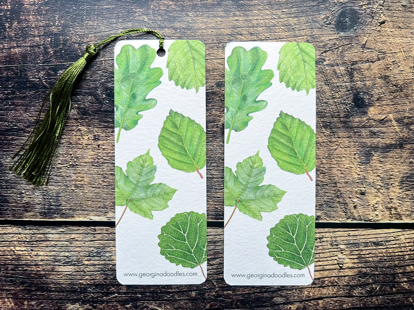 A photograph of a bookmark with British leaves on, photographed on an open book