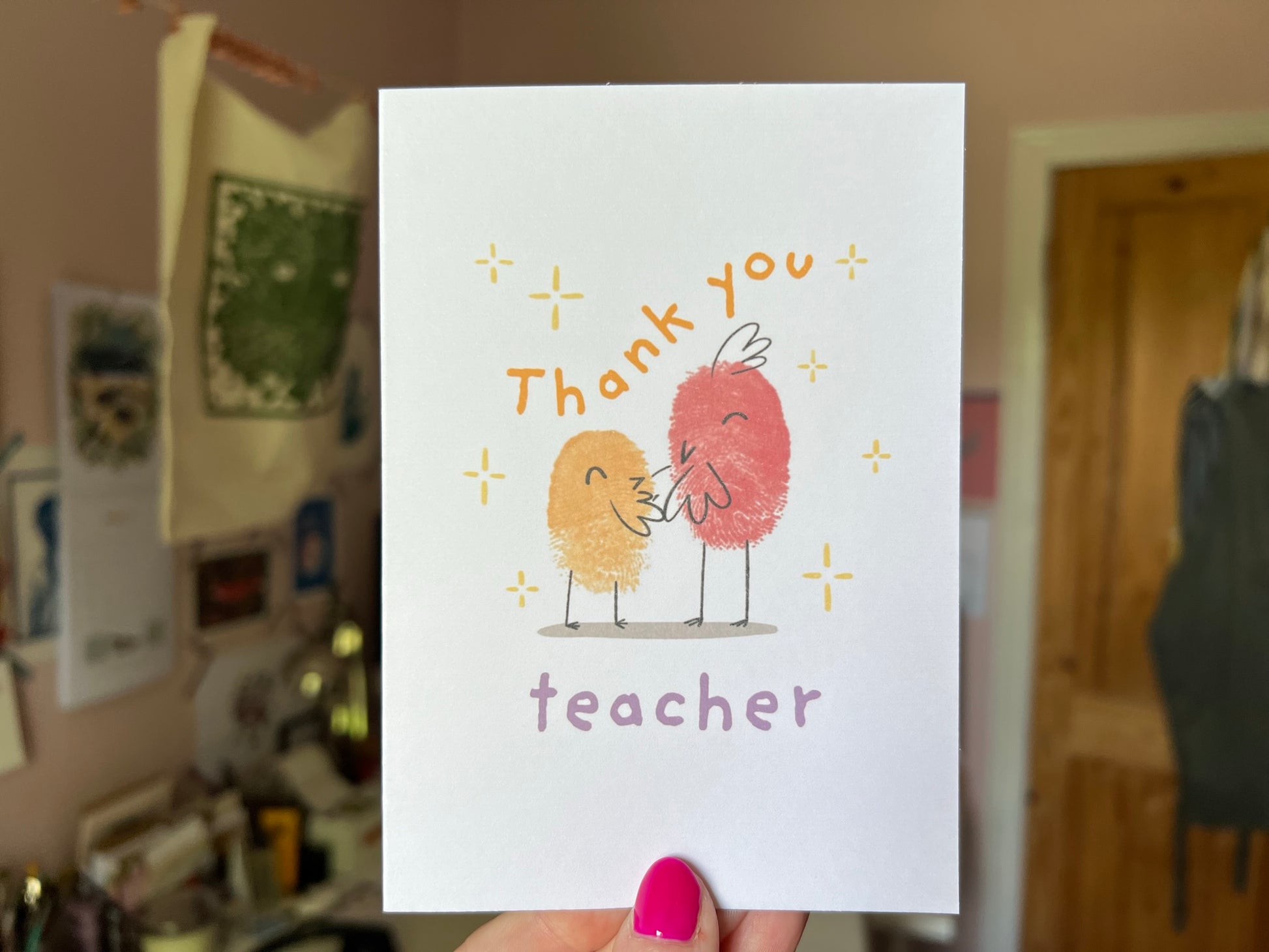 An A6 card reading thank you teacher, that has two finger printed birds on the front.