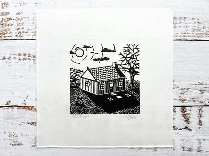 A small lino print of a little house
