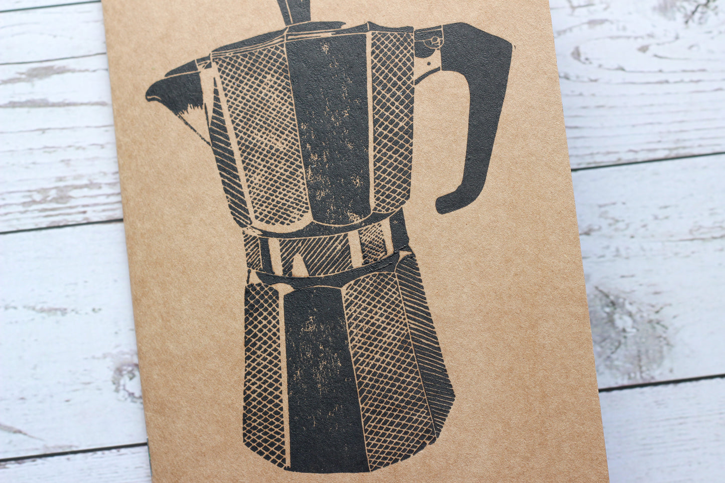 A lino printed sketchbook with a print of a coffee moka pot on the front