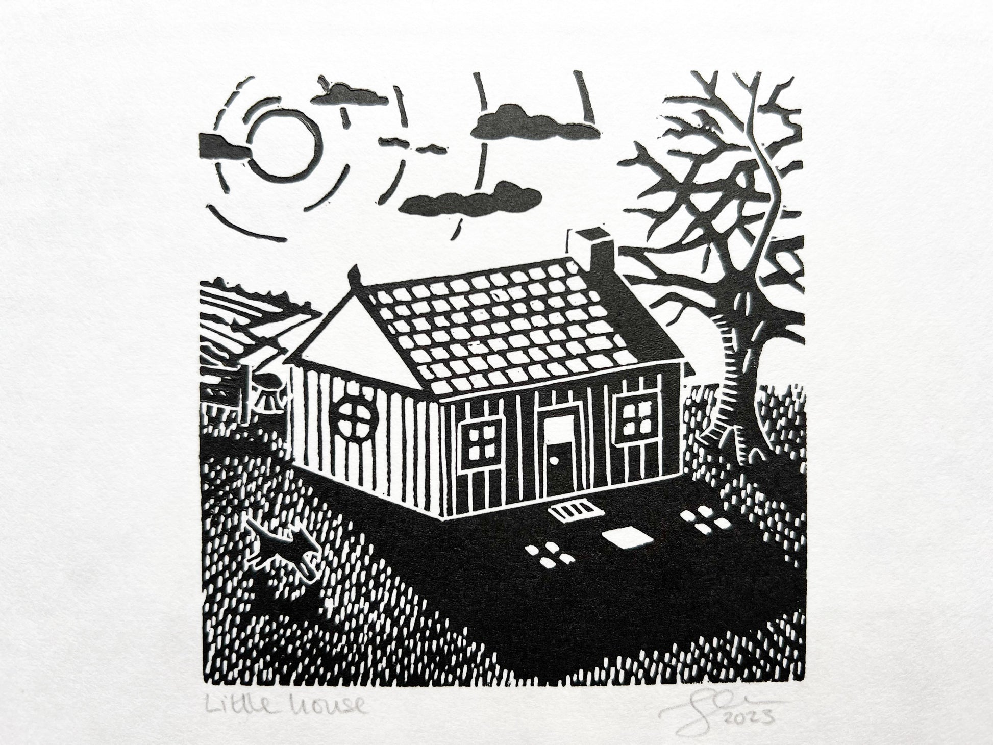 A small lino print of a little house