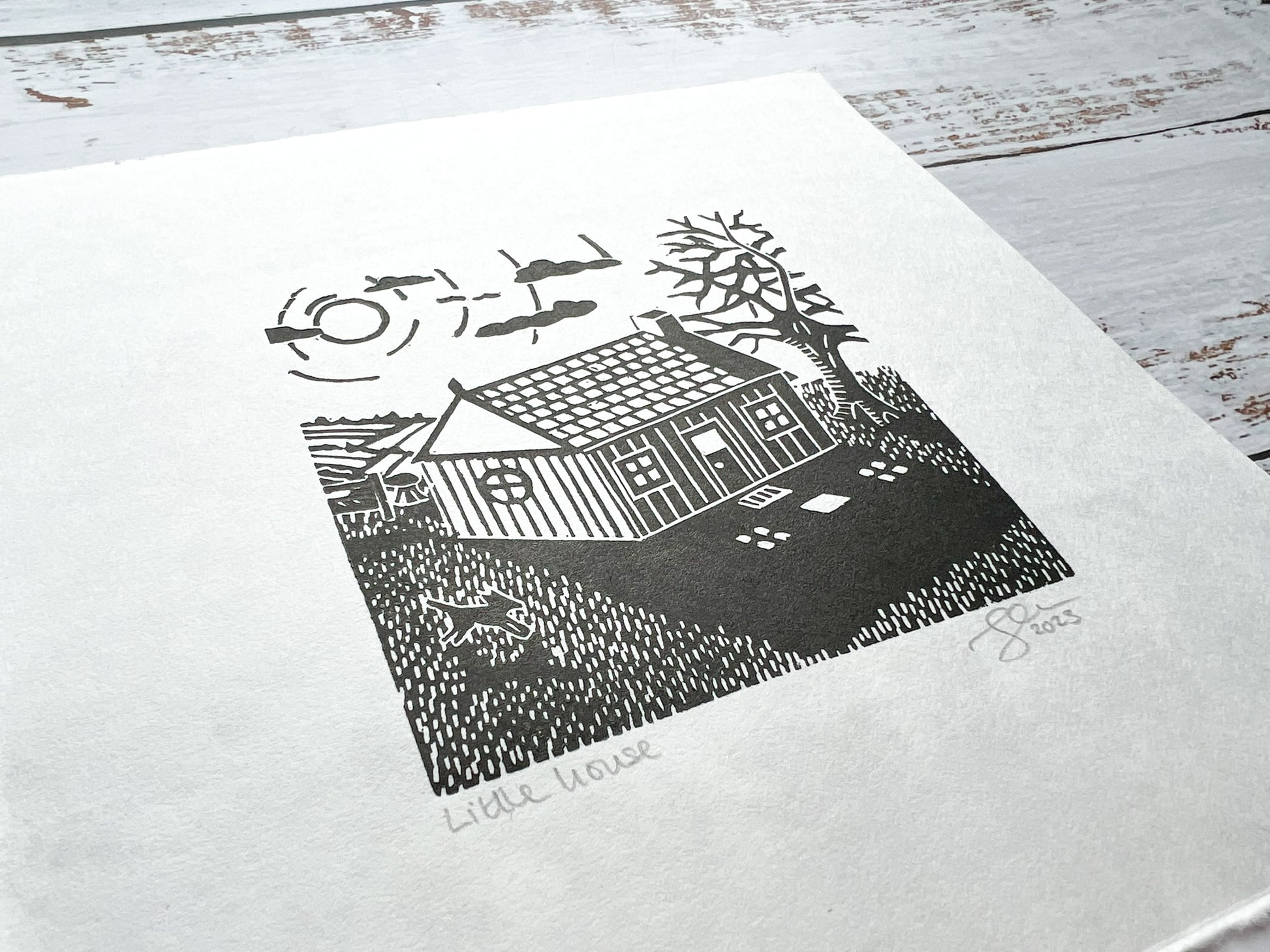 A small lino print of a little house