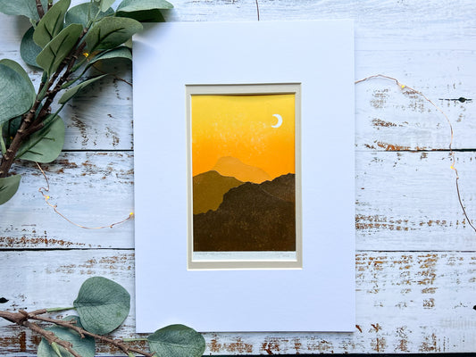 A multiblock lino print of mountains in the sunset, mounted.