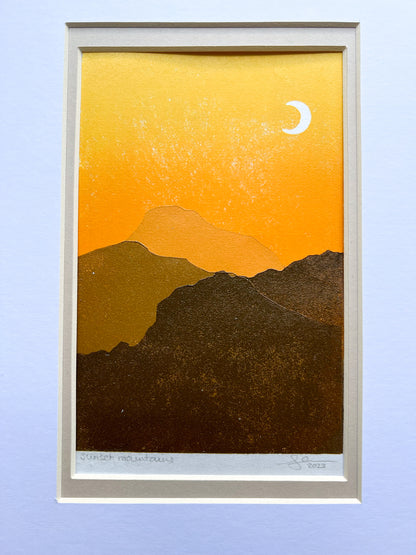 A multiblock lino print of mountains in the sunset, mounted.