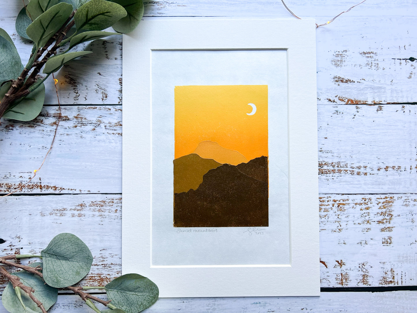 A multiblock lino print of mountains in the sunset, mounted.