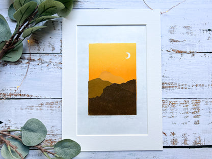A multiblock lino print of mountains in the sunset, mounted.