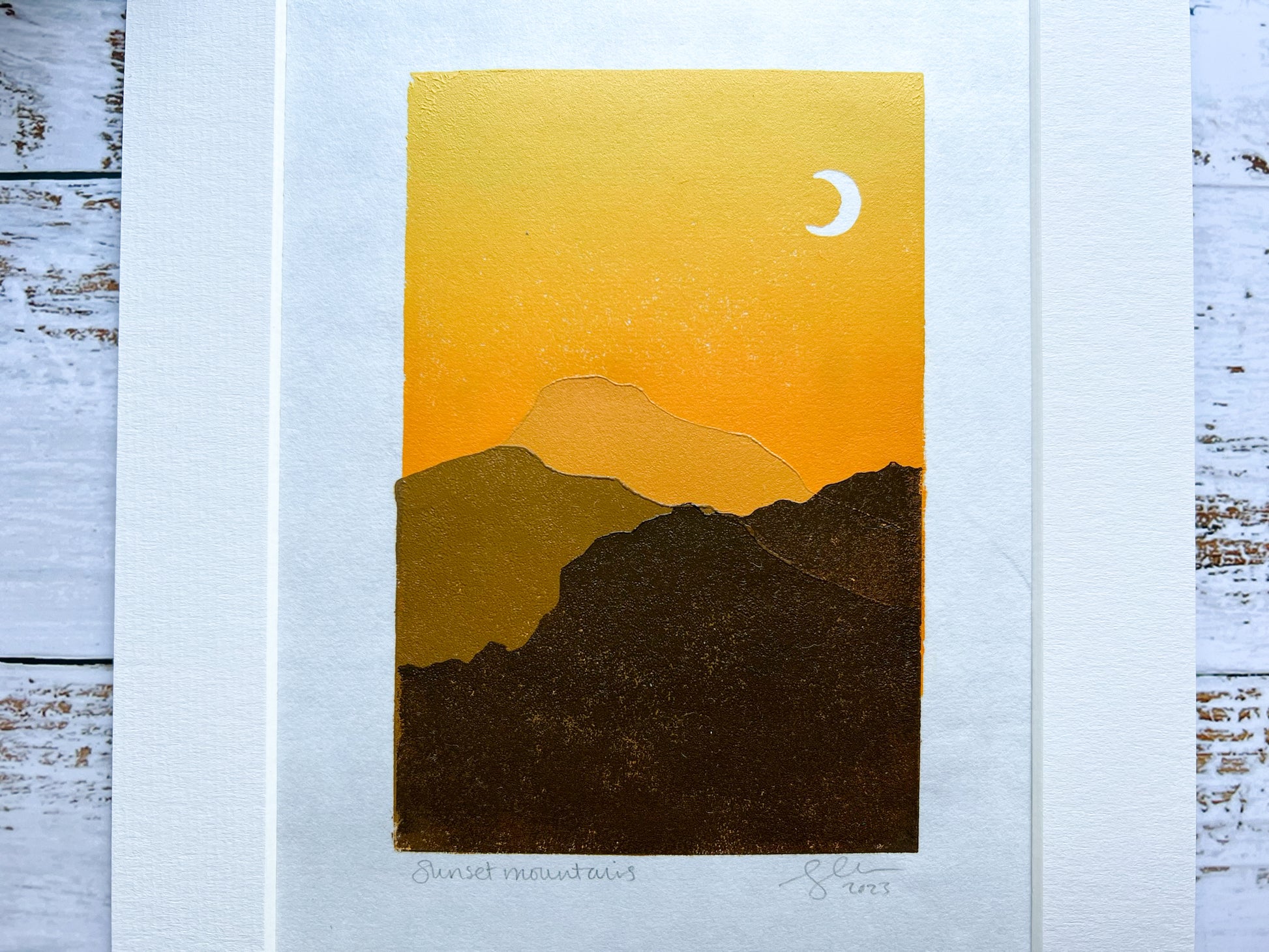 A multiblock lino print of mountains in the sunset, mounted.