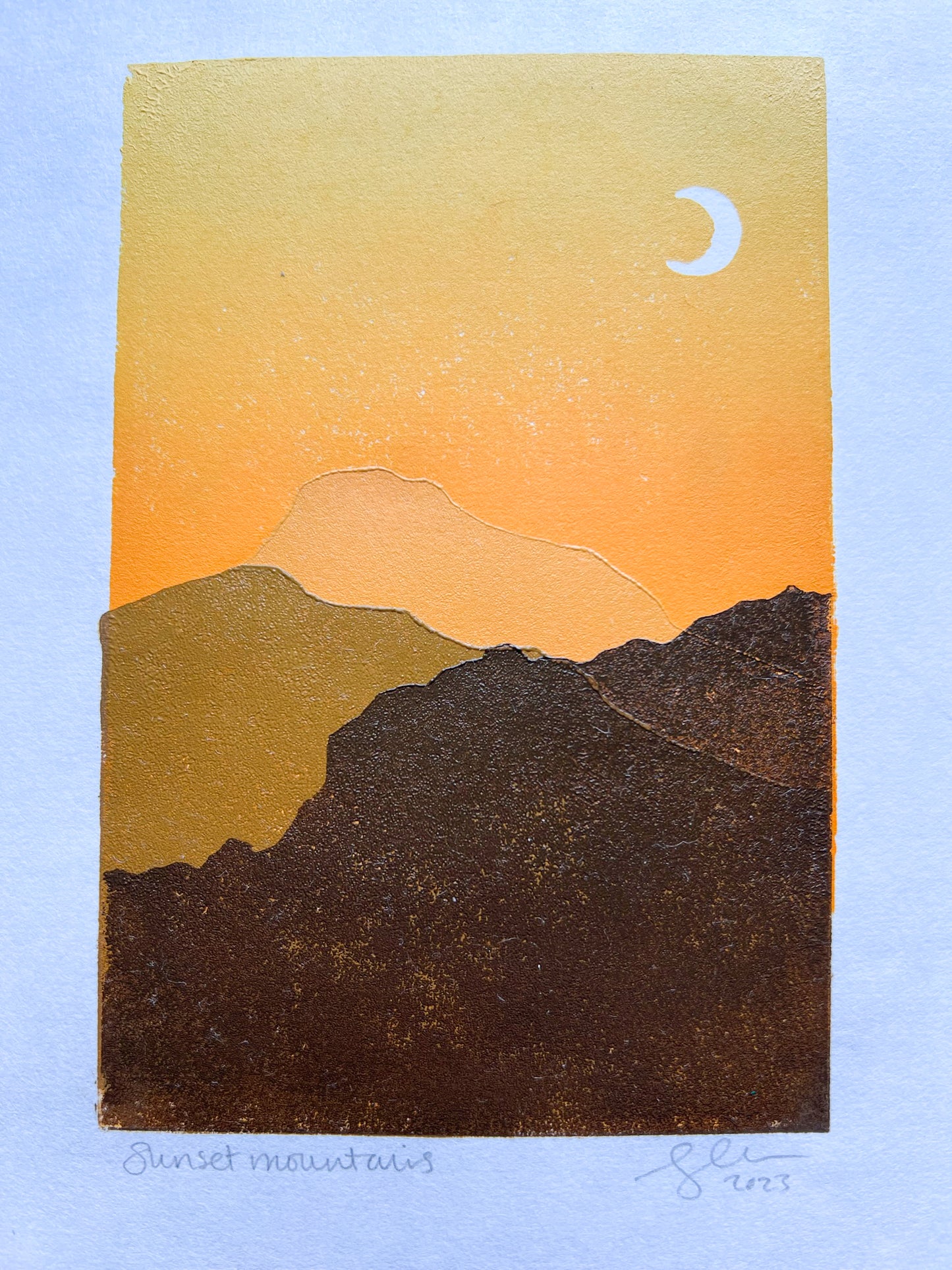 A multiblock lino print of mountains in the sunset, mounted.