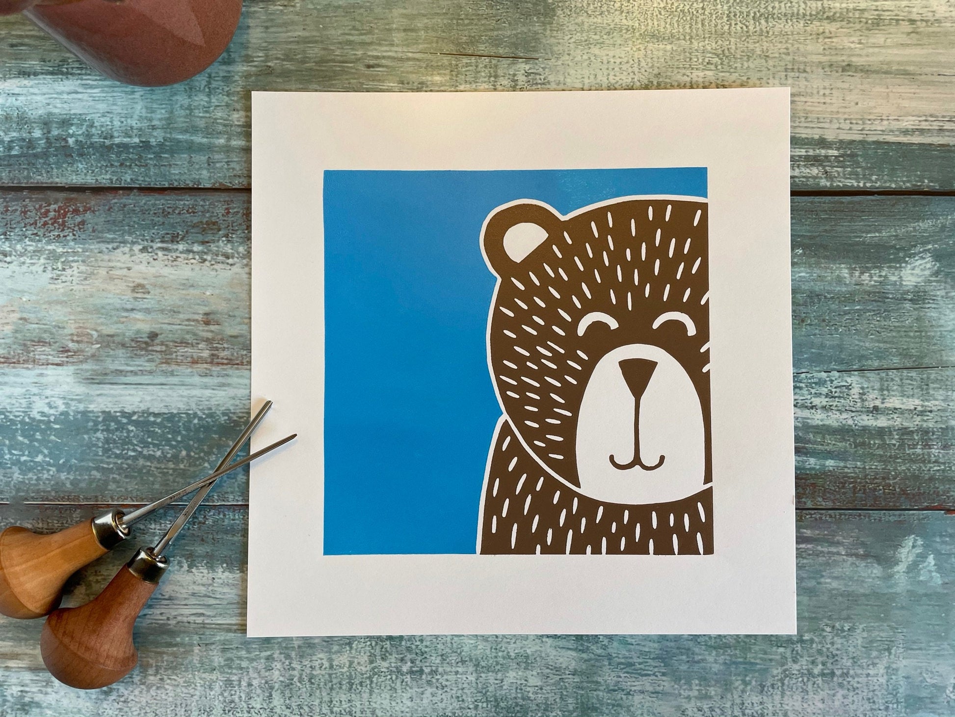 A multiblock lino print of a bear with a blue background