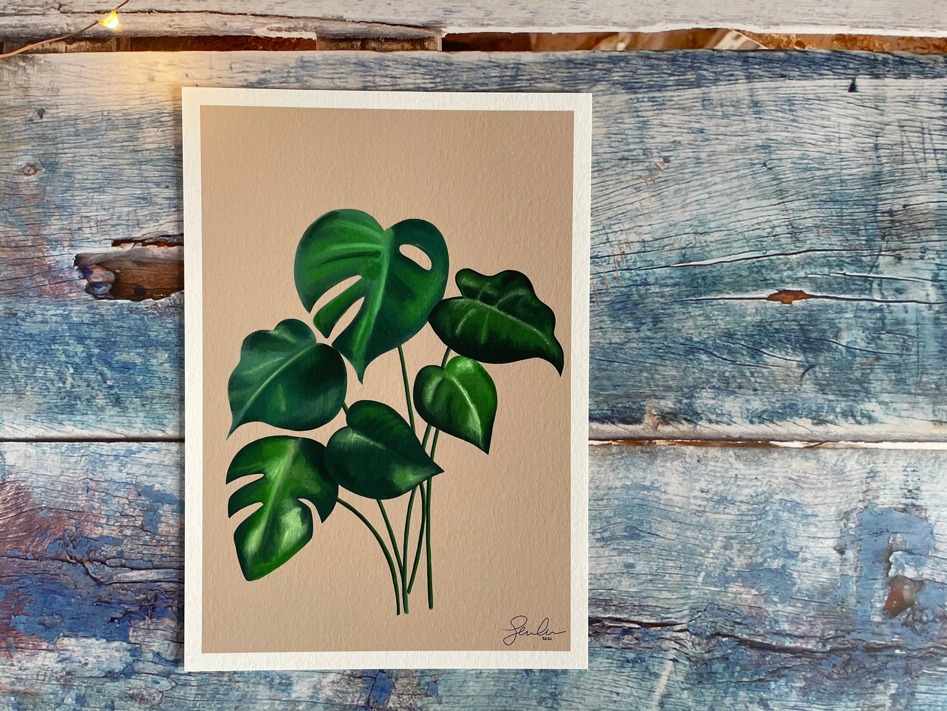 A photo of an A4 and A5 giclee print of a digitally illustrated monstera