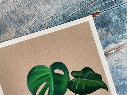 A photo of an A4 and A5 giclee print of a digitally illustrated monstera